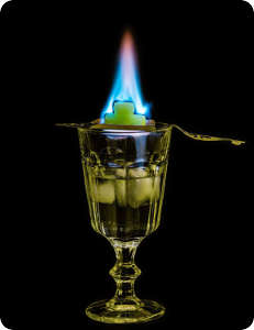 Absinth trinken, Absinthlöffel mit brennendem Zucker, Feuerritual