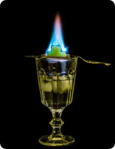 Absinth trinken, Absinthlöffel mit brennendem Zucker, Feuerritual